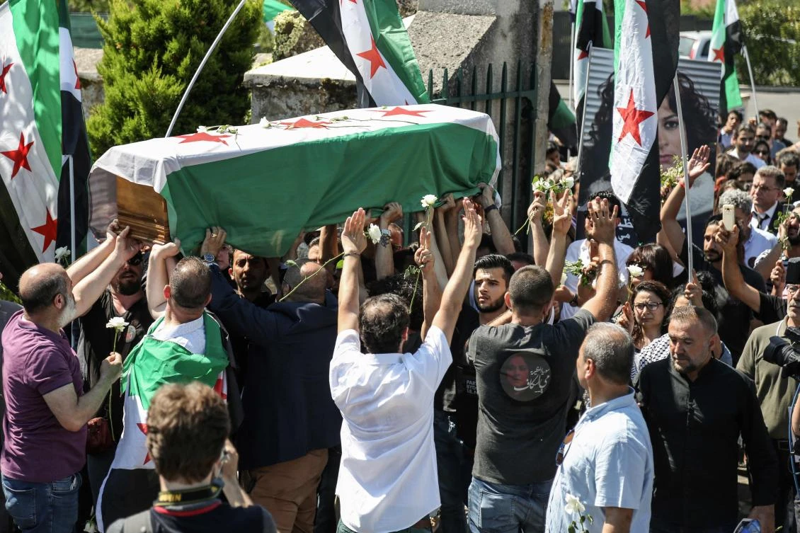 The coffin of Syrian actress and democracy activist exiled by the regime, Mai Skaf, is carried in the cemetery of Dourdan, a southwestern Paris suburb, during her funeral on August 3, 2018. (AFP)
