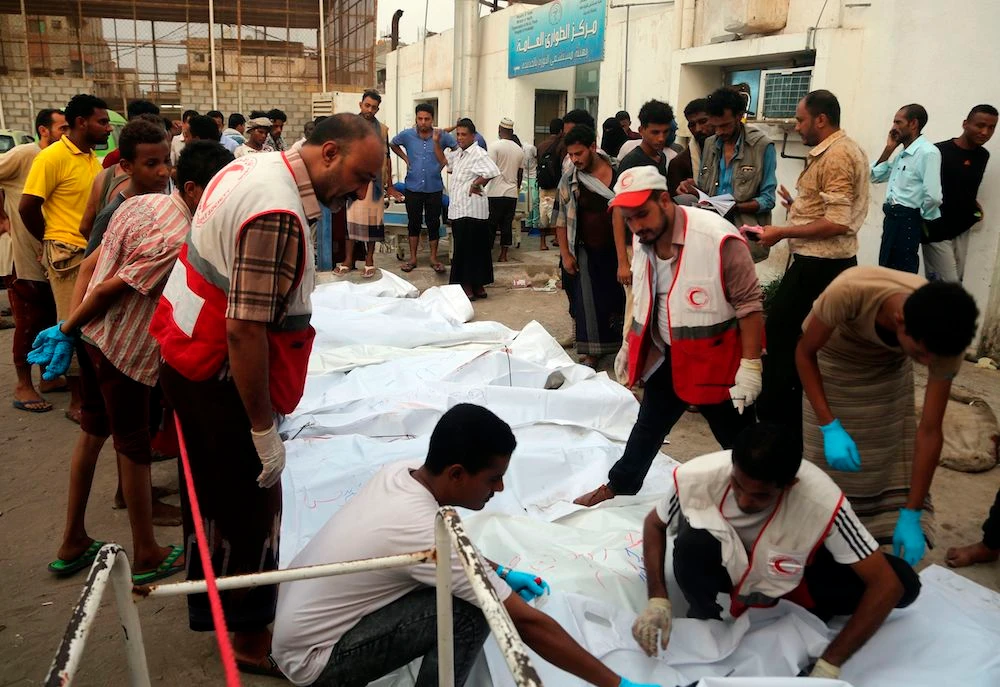 Relatives of victims gather around their bodies outside a hospital morgue after an air strike in the Red Sea town of Hodeida on August 2, 2018. (AFP)