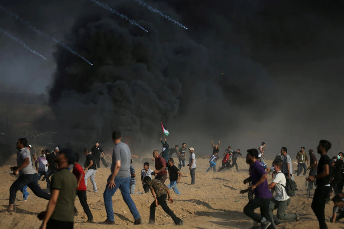 Tear gas canisters are fired by Israeli troops towards Palestinian demonstrators as they run during a protest demanding the right to return to their homeland at the Israel-Gaza border, in the southern Gaza Strip August 3, 2018. (File photo: Ibraheem Abu Mustafa/Reuters)
