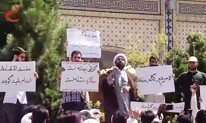 In this video grab made from a video by Nasim News Agency, a cleric speaks to a crowd of protesters in Mashhad on Friday. (AFP)