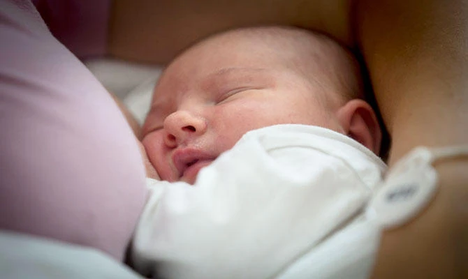 Aleksandra Milenovic watches her 24 hours old baby Milica after breastfeeding her at the Obstetrics and gynecological Clinic "Narodni Front" in Belgrade on July 31, 2018. (AFP)