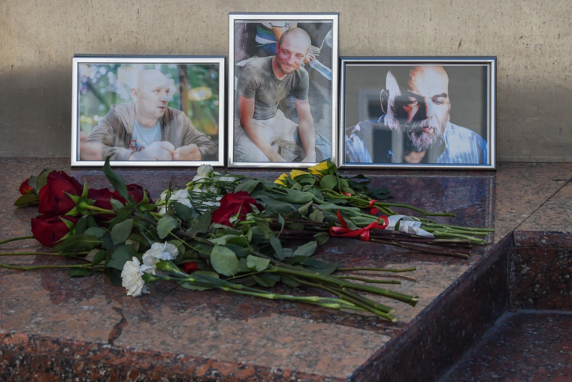 Flowers left in front of the photographs of Russian journalists (L-R) Alexander Rastorguyev, Kirill Radchenko and Orkhan Dzhemal, who were recently killed in the Central African Republic, outside the Central House of Journalists. (Vasily Maximov/AFP)