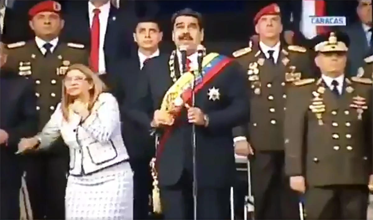 Screengrab taken from a handout video released by Venezuelan Television (VTV) showing Venezuelan President Nicolas Maduro (C), his wife Cilia Flores (L) and military authorities reacting to a loud band during a ceremony to celebrate the 81st anniversary of the National Guard in Caracas on August 4, 2018. (AFP)