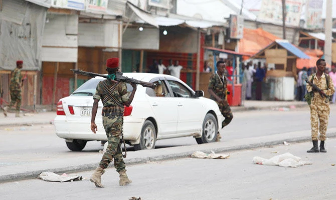 Somali government soldiers walk near a car after two armed militants were killed by Somali forces, at the Benadir checkpoint in Mogadishu, Somalia ON Sunday. (REUTERS)