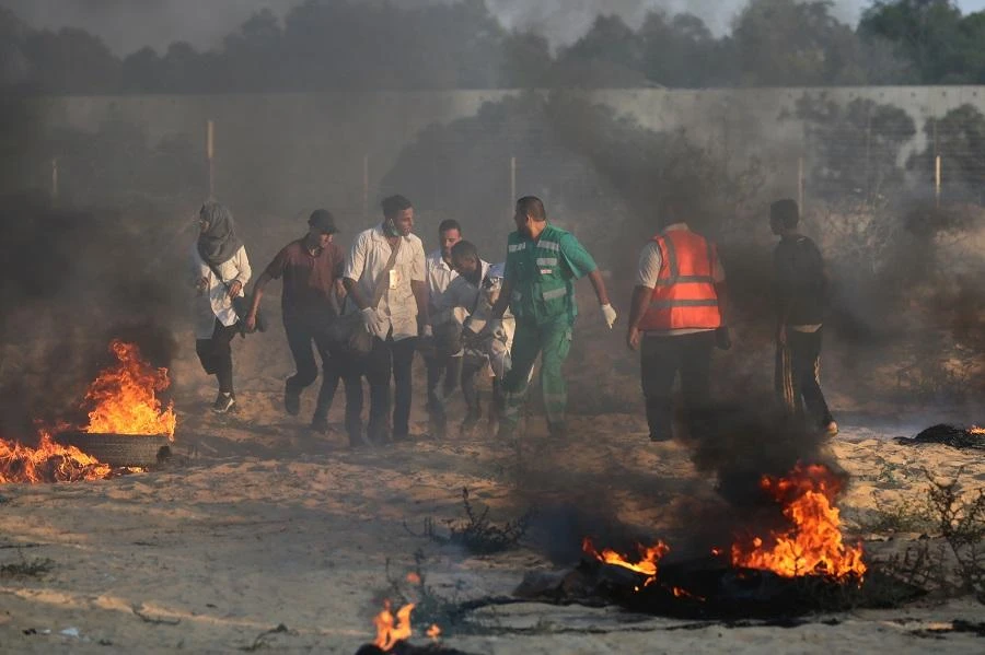 Palestinian protesters and rescuers carry a wounded protester during a demonstration at the Israel-Gaza border, in Khan Yunis in the southern Gaza Strip on August 3, 2018. (AFP)