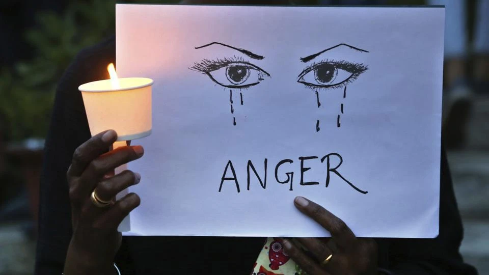 A woman holds a candle and placard seeking an end to sexual violence against women during a protest in Bangalore. (AP Photo)