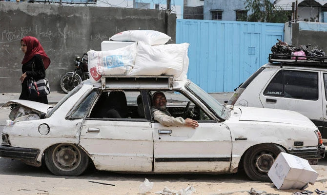 Palestinians sit in a car after they received aids from a United Nations food distribution centre in Jabalia refugee camp in the northern Gaza Strip on Wednesday. (AFP)