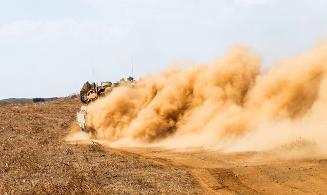 An Israeli Merkava battle tank leaves a trail of dust as it speeds during a military exercise in the Israeli-annexed Golan Heights along the border with Syria on August 8, 2018. (AFP)