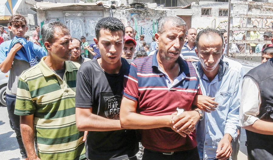 Palestinians condole the father of 23-year-old Enas Khammash, center, during her and her daughter’s funeral in Deir Al-Balah in the central Gaza Strip on Thursday. (AFP)