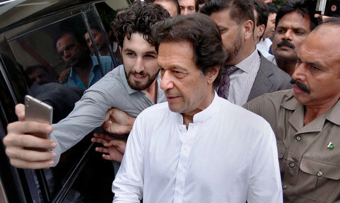 A Pakistani takes selfie with Imran Khan, center, head of the Pakistan Tehreek-e-Insaf party, as he leaves a party meeting in Islamabad, Pakistan, in this Aug. 6, 2018 photo. (AP)