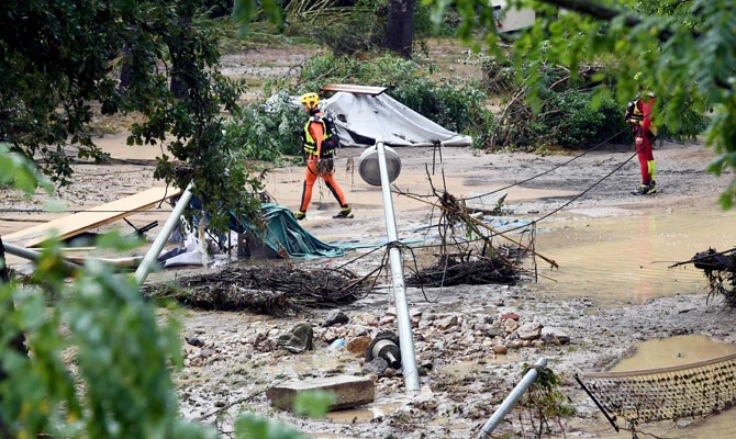 Rescuers stand in a flooded and damaged area of a camping as storms and heavy rains sweep across France on August 9, 2018 in Saint-Julien-de-Peyrolas, southern France. (AFP)