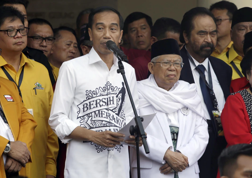 Indonesian President Joko "Jokowi" Widodo, center left, speaks as his running mate Ma'ruf Amin, center right, listens prior to formal registration as candidates for the 2019 presidential election in Jakarta, Indonesia. Friday, Aug. 10,2018. (AP)