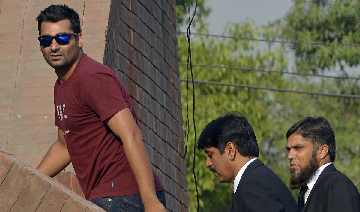 In this file photo, suspended Pakistani cricketer Shahzaib Hasan, left, arrives with his lawyers to appear before a tribunal in Lahore on March 31, 2017. (ARIF ALI/AFP)