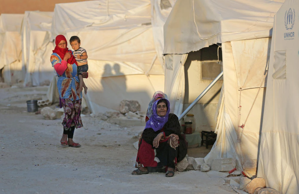 Internally displaced woman sits outside a tent in Idlib province, Syria, on July 30, 2018. (REUTERS/ Khalil Ashawi)