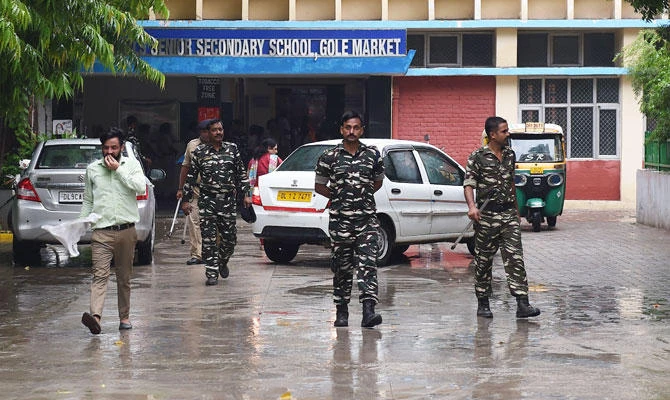 Indian security forces walk inside the government school where a seven years old girl student was sexually assaulted, in New Delhi on August 10, 2018. (AFP)
