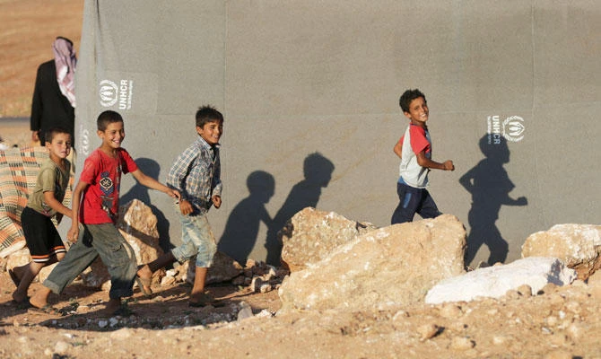Internally displaced boys run outside a tent in Idlib province, Syria July 30, 2018. (REUTERS)