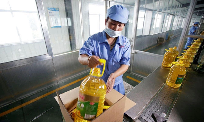 A worker packs bottles of soybean oil made from the US imported soybeans at the plant of Liangyou Industry and Trade Co., Ltd in Qufu, Shandong province, China July 4, 2018. (REUTERS)
