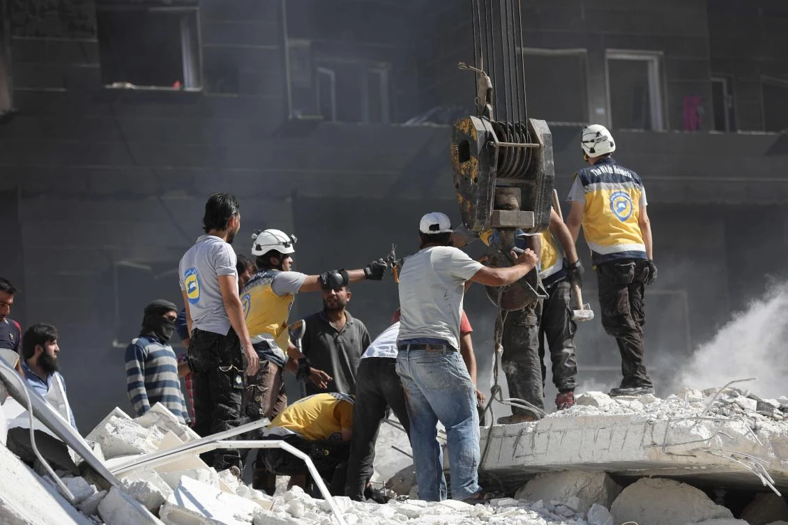 Syrian rescue workers known as White Helmets sift through the rubble of destroyed buildings on August 12, 2018 following an explosion at an arms depot in a residential area in Syria's northern Idlib province city of Sarmada in which 69 people were reportedly killed. (AFP)