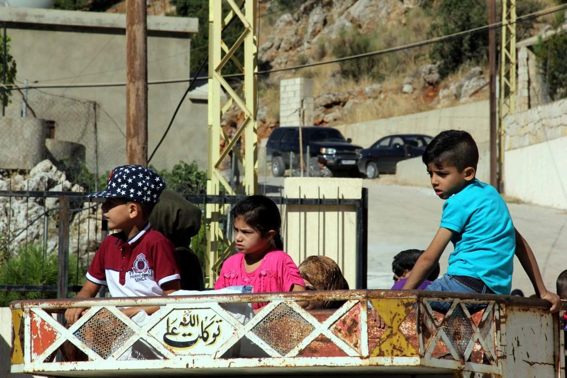 Syrian refugees prepare to be evacuated from the southern Lebanese village of Shebaa on August 13, 2018. Lebanon says it currently hosts some 1.5 million Syrian refugees, of whom fewer than one million are registered with the UN. (AFP/Ali Dia)
