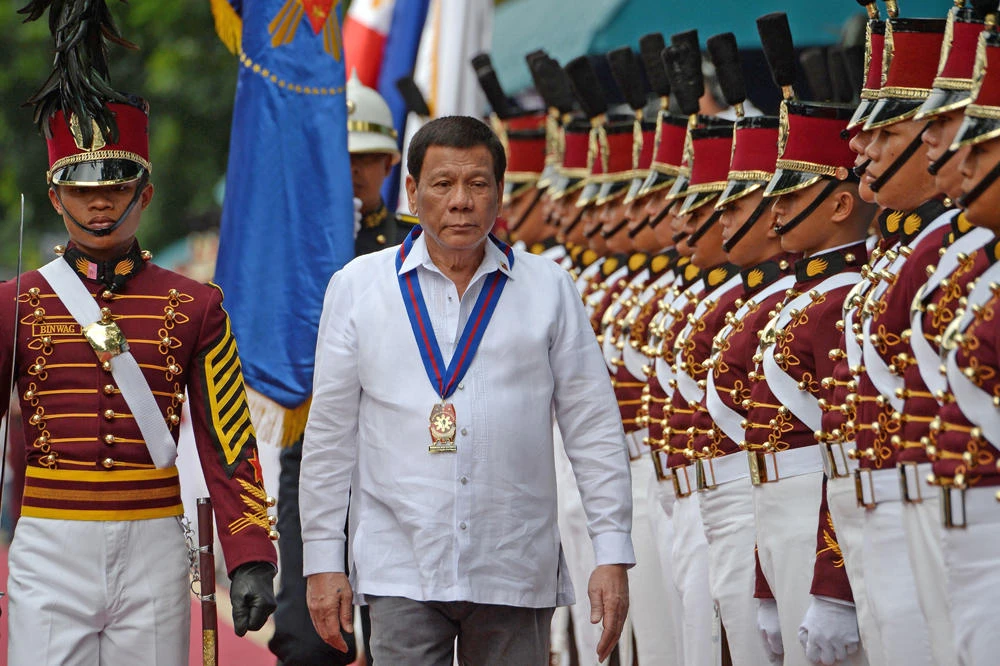 Philippine President Rodrigo Duterte reviews an honor guard during arrival honors for the 117th police anniversary celebration at the national headquarters in Manila on August 8, 2018. After railing against corruption in the police force last week, Duterte on Monday sacked 20 military officials over accusations of fraud and graft in purchases of military medical supplies. (AFP / TED ALJIBE)