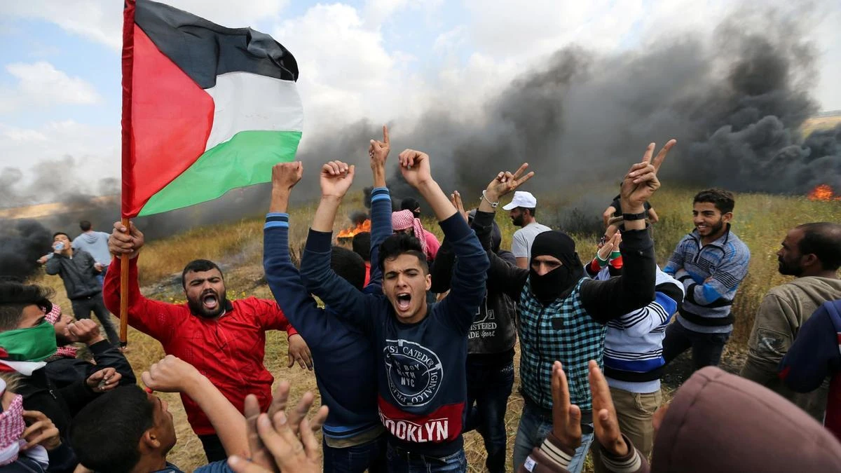 Smoke billows behind a group of Palestinians during a tent city protest along the Israel border with Gaza. (File photo: Reuters)
