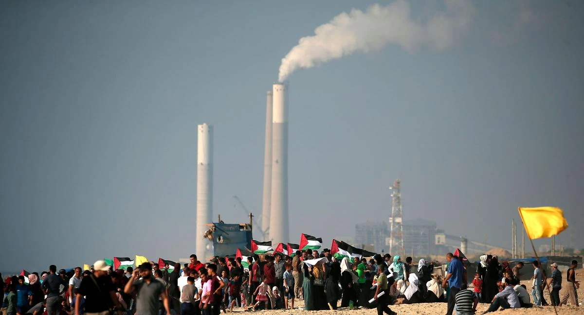 Palestinians participate in a protest against the more than a decade-long Israel's naval blockade of Gaza, in Beit Lahya on the border with Israel in the northern Gaza strip on August 11, 2018. The Israeli Rutenberg power station can be seen in the background. (AFP)