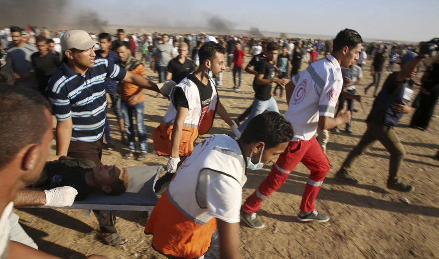 Medics and protesters evacuates a wounded youth near the fence of the Gaza Strip border with Israel, during a protest east of Khan Younis, southern Gaza Strip,on Aug. 17, 2018. UN Secretary-General Antonio Guterres on Friday presented four options aimed at boosting the protection of Palestinians in Israeli-occupied territories. (AP Photo/Adel Hana)