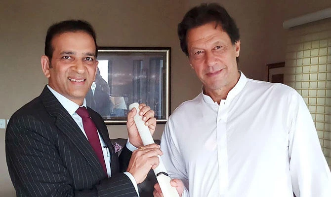 In this handout photo released by the centrist political party Pakistan Tehreek-e-Insaf (PTI) on August 10, 2018, Indian high commissioner to Pakistan Ajay Bisaria (L) presents a cricket bat to Pakistan's cricket hero and chairman Pakistan Tehreek-e-Insaf (PTI) Imran Khan (R) during a meeting in Islamabad on August 10, 2018. (AFP)
