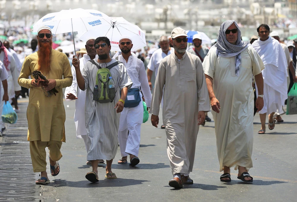 Muslim pilgrims walk on a street in the holy city of Makkah on August 18, 2018, ahead of the start of the annual Hajj pilgrimage. (AFP / AHMAD AL-RUBAYE)