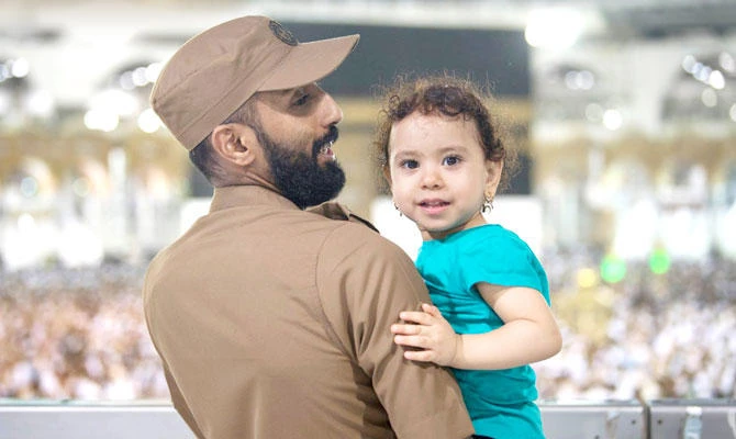 A Hajj security man takes care of a child. Security forces have been deployed around the clock to deal with all emergency cases. (SPA)