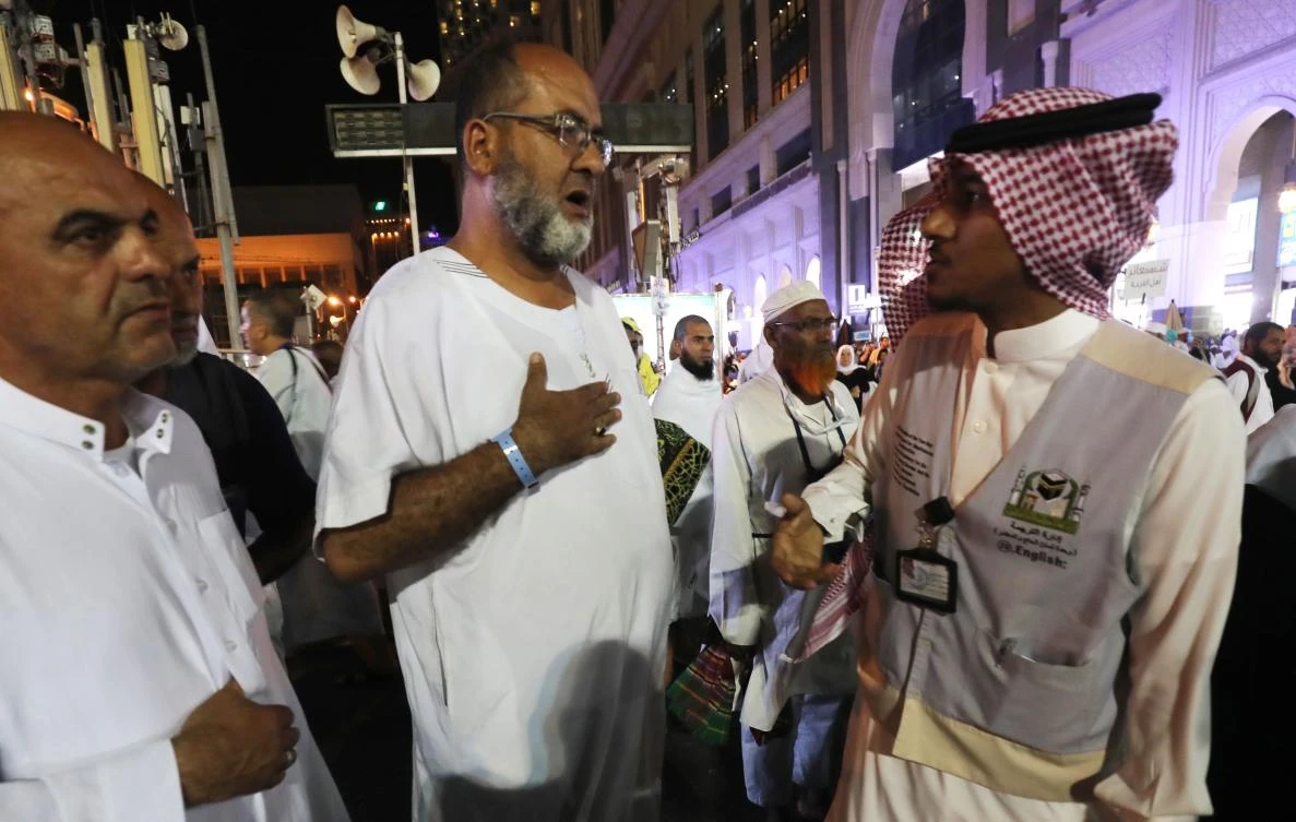 Muslim pilgrims speak to a translator in the Saudi holy city of Makkah, ahead of the start of the Hajj pilgrimage, on Aug. 17, 2018. (AFP/Ahmad Al-Rubaye)