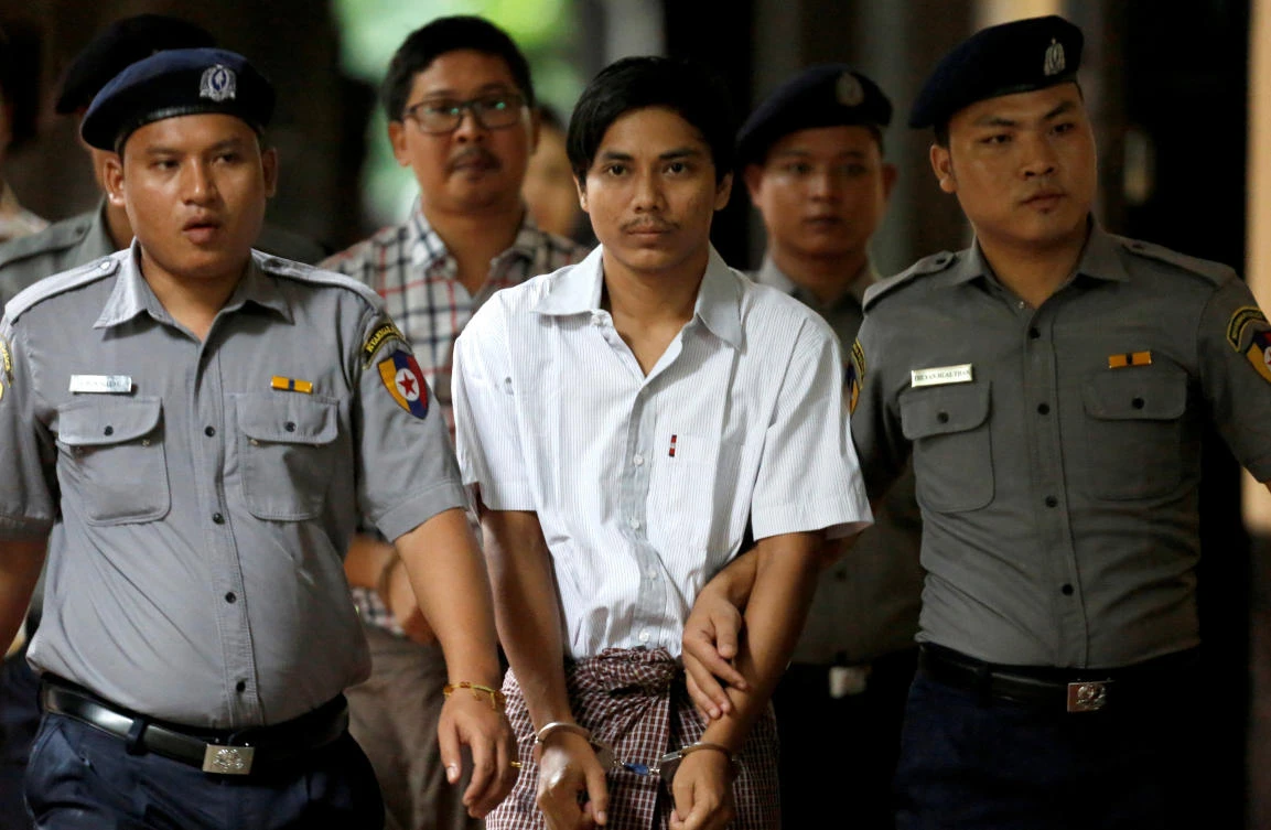 Detained Reuters journalists Kyaw Soe Oo, center front, and Wa Lone, center back, are accused of breaching the colonial-era Official Secrets Act, which carries a maximum sentence of 14 years in prison. (Reuters)