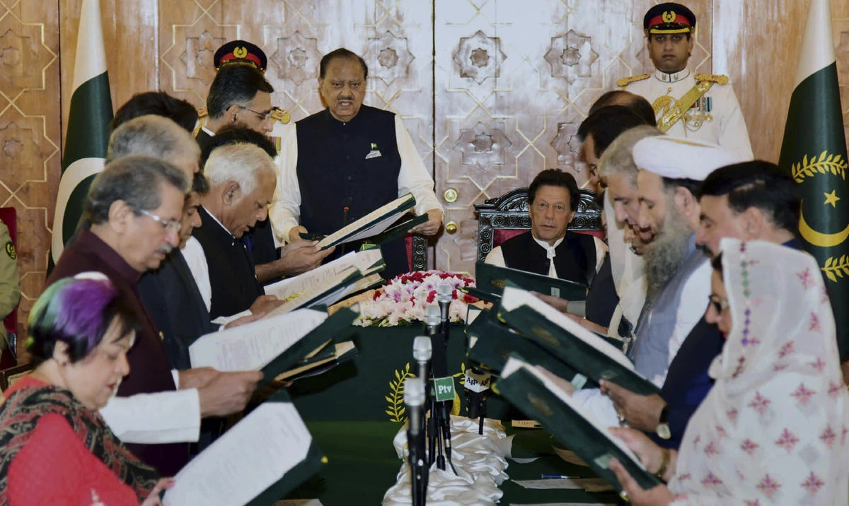 Pakistan’s President Mamnoon Hussain, center left, administrates oath of office to federal ministers while Prime Minister Imran Khan, center right, looks on during a ceremony at a presidential palace in Islamabad on Monday August 20. (Press Information Department via AP)