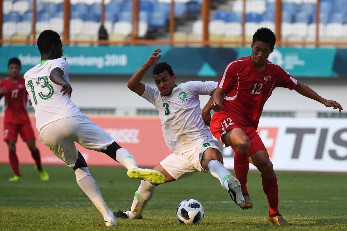 Mohammad Maizn Albassas of Saudi Arabia (C) fights for the ball with Hang Yong Thae of North Korea (R) (AFP)