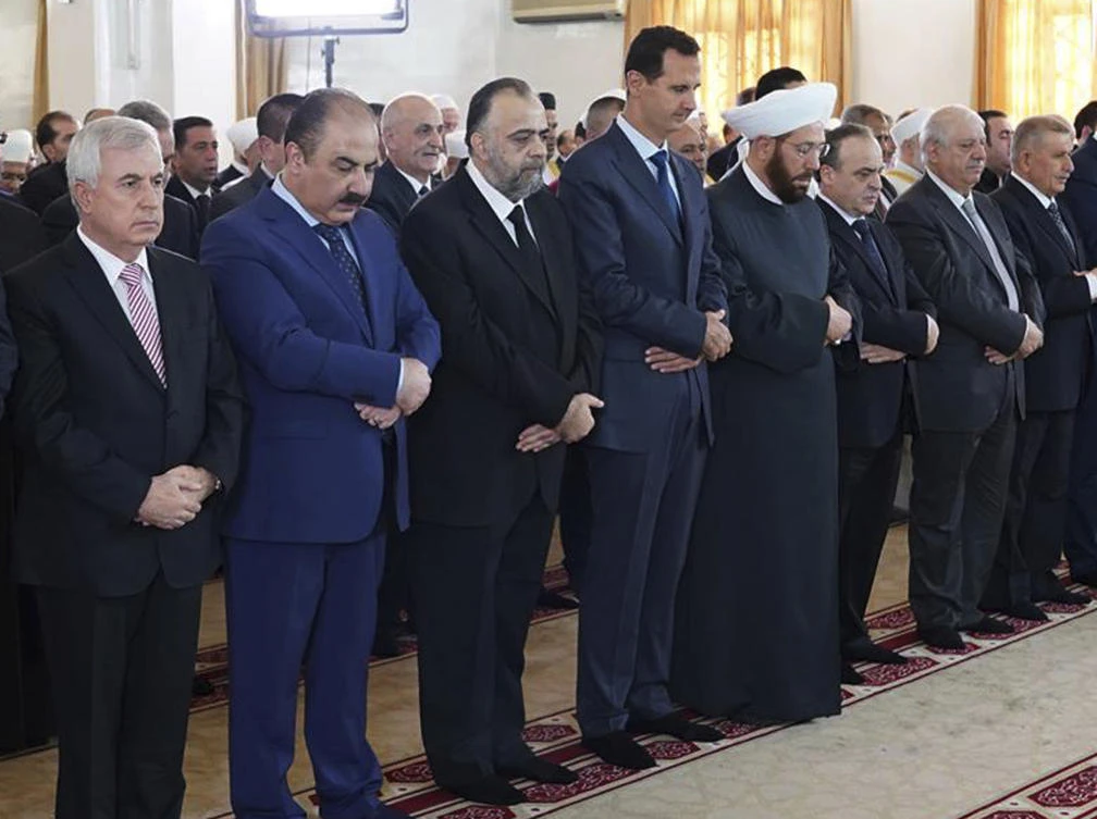 Syrian President Bashar Assad, fourth from left, prays on the first day of Eid Al-Adha at Al-Rawda mosque, in Damascus, Syria, Tuesday, Aug. 21, 2018. (Syrian Presidency Facebook page via AP)