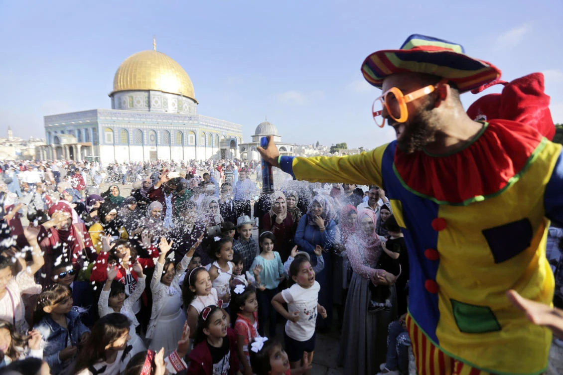 A clown sprays foam on the first day of Eid Al-Adha near the Dome of the Rock Mosque in the Al-Aqsa Mosque compound in Jerusalem’s old city. (AP)