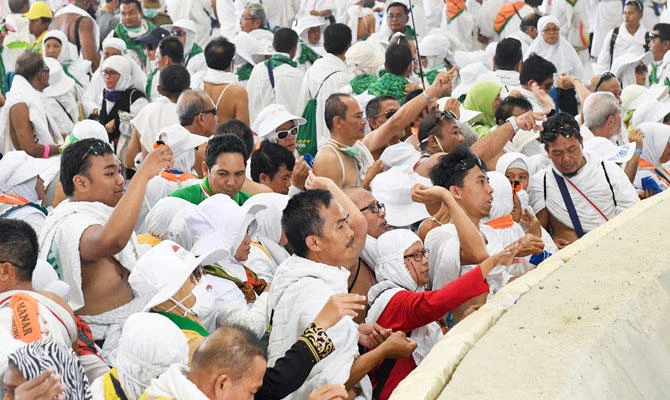 Muslim pilgrims cast stones at the huge stone pillar in the symbolic stoning of the devil during the annual Hajj pilgrimage on the first day of Eid al-Adha in Mina, outside the holy city of Makkah, Saudi Arabia, on Tuesday, Aug. 21, 2018. (SPA)