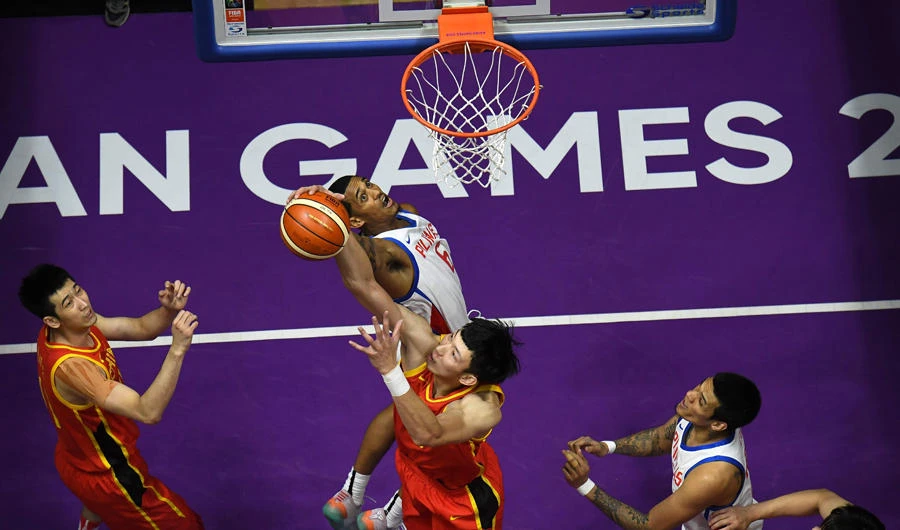 China's Zhou Qi (bottom C) blocks a shot by the Philippines' Jordan Clarkson (top C) in their men's basketball preliminary Group D game between China and the Philippines during the 2018 Asian Games in Jakarta on August 21, 2018. (AFP / Lillian Suwanrumpha)