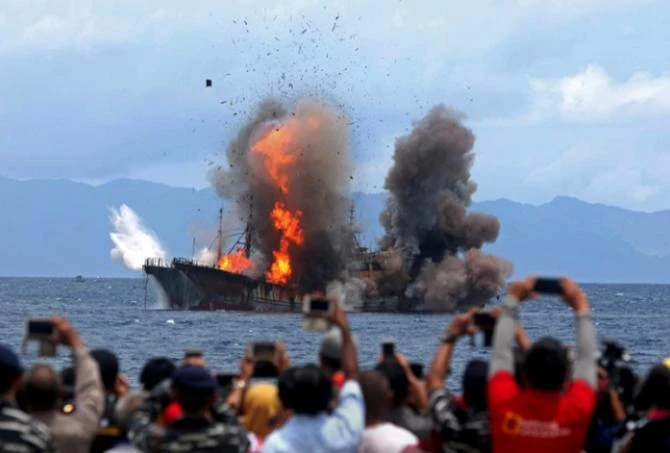 In this April 1, 2017 photo, people take pictures of a burning ship in Indonesia's Ambon Island as the government destroyed foreign boats that had been caught illegally fishing in the country's waters. (File photo/Antara Foto via REUTERS)