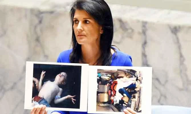 US Ambassador to the UN Nikki Haley holds photos of victims at the UN Security Council on April 5, 2017, about the suspected deadly chemical attack in Syria. (AFP)