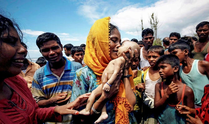 Hamida, a Rohingya refugee woman, weeps as she holds her 40-day-old son after he died as their boat capsized before arriving on shore in Shah Porir Dwip, Teknaf, Bangladesh, September 14, 2017. (REUTERS)