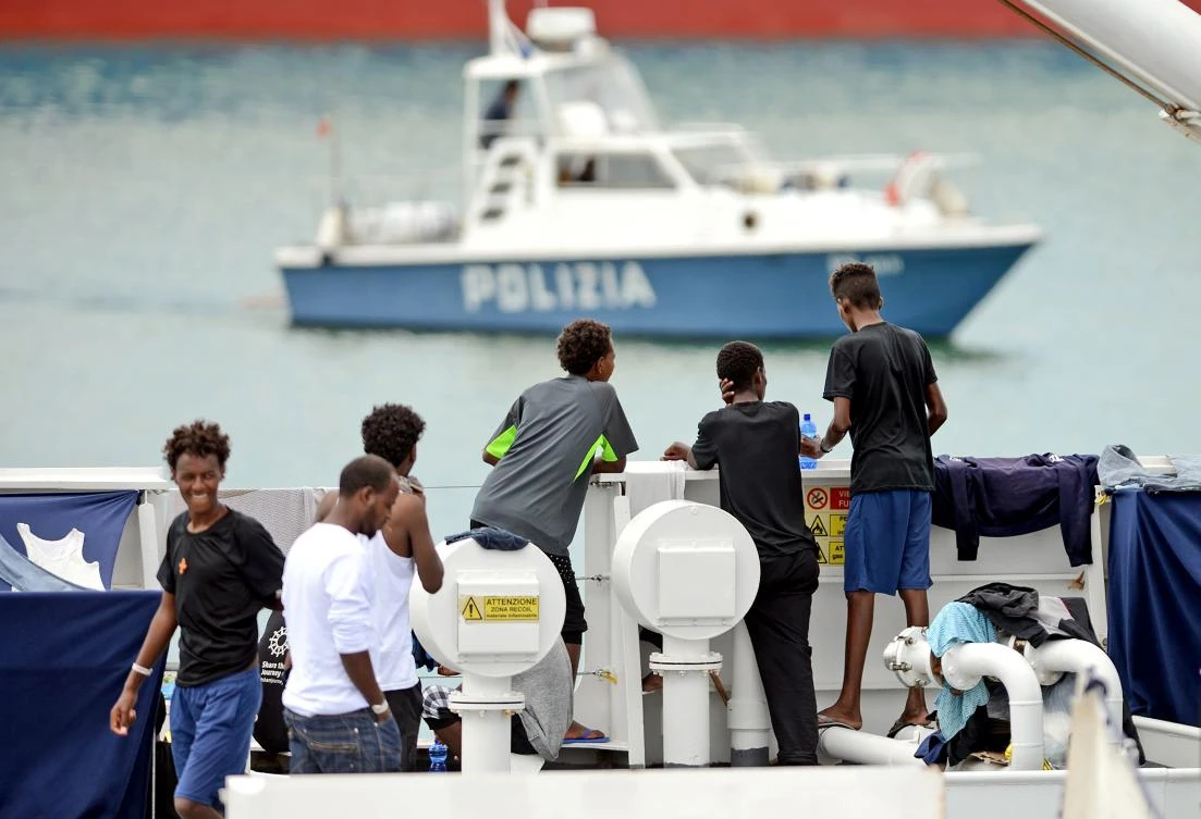 Migrants gather on the deck of the Italian Coast Guard vessel "Diciotti" in the Sicilian port of Catania, on August 23, 2018, as they wait to disembark following a rescue operation at sea. (AFP)