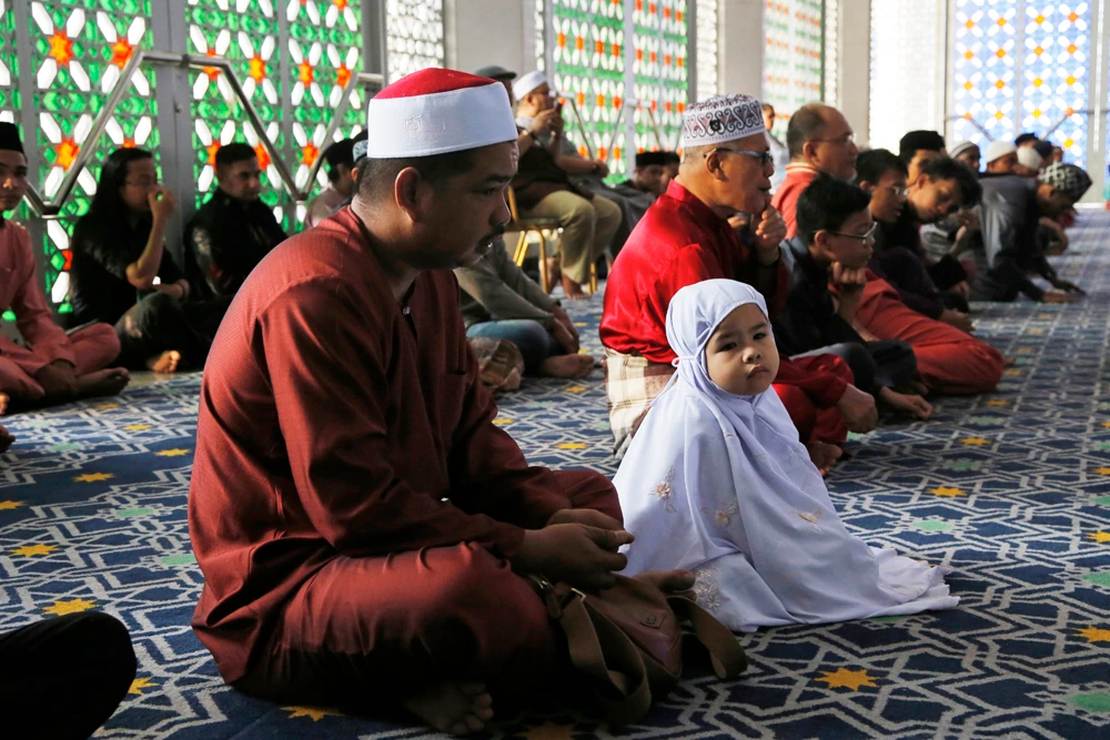 A young Malaysian Muslim child and her father pray during the Islamic holiday of Eid al-Adha at a mosque in Shah Alam, Malaysia, on Aug. 22, 2018. (AP Photo/Yam G-Jun)