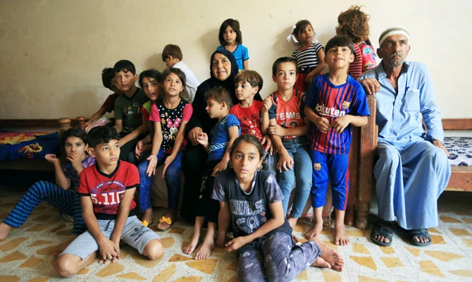 An Iraqi woman Sana Ibrahim al-Taee, 64, whose five sons were killed by Islamic State militants, poses for a photograph with her husband and her grandchildren at her home in Mosul, Iraq July 30, 2018. (REUTERS)