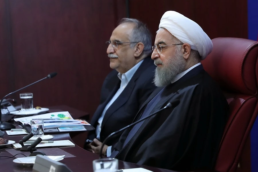 A handout picture provided by the office of Iranian President Hassan Rouhani show him (R) sitting next to Minister of Economy, Masoud Karbasian, during a meeting with members of the ministry, (AFP file photo)