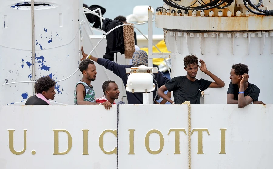 Migrants gather on the deck of the Italian Coast Guard vessel "Diciotti" in the Sicilian port of Catania, on August 23, 2018, as they wait to disembark following a rescue operation at sea. (AFP)