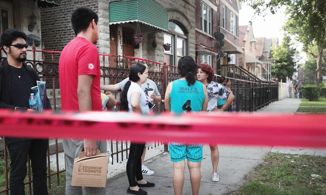 Poeple watch as firefighters continue to work at the scene of a residential fire where eight people perished, including six children, on August 26, 2018 in Chicago, Illinois. (AFP)
