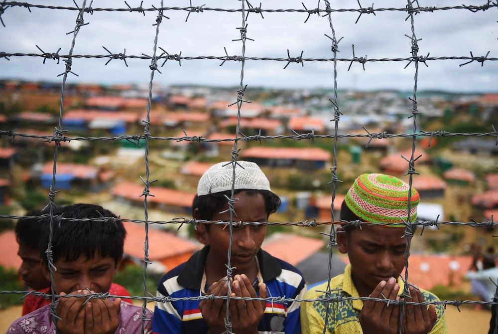 Rohingya refugees perform prayers at the Kutupalong camp in Bangladesh to mark one year since the military crackdown forced them to flee. (AFP)