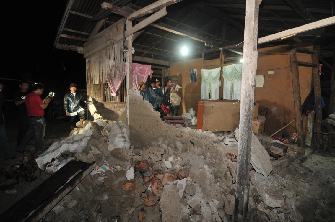 In this Sunday, Aug. 19, 2012 photo, residents and journalists inspect a house that was damaged after a magnitude 6.3 earthquake struck in Sigie, Sulawesi island, Indonesia. (AP)