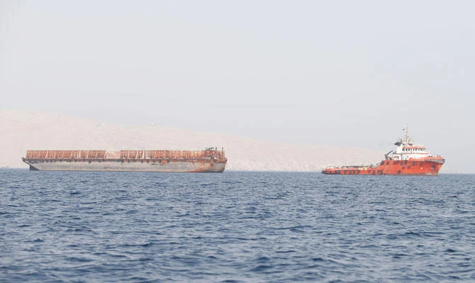 A tug boat moves cargo towards the Strait of Hormuz, in Musandam province, Oman, July 20, 2018. (REUTERS)